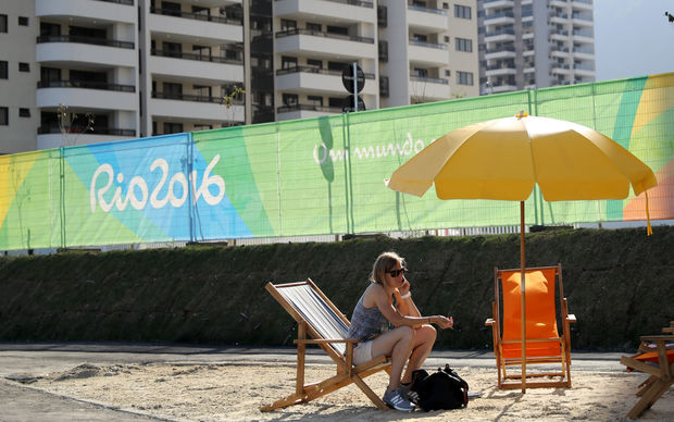 A visitor talks on mobile phone at a fake beach on the entrance of The Olympic Village on Barra da Tijuca neighboorhood in Rio de Janeiro