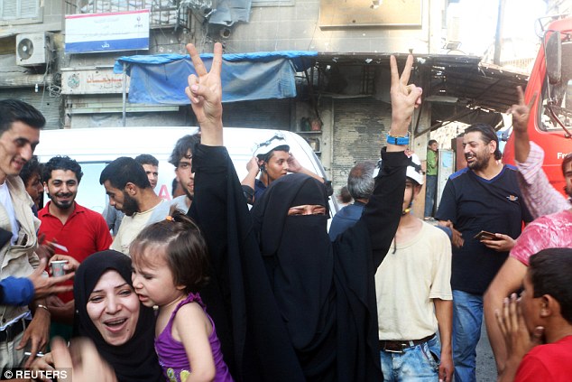 A woman celebrates with the victory sign over the news that the siege of the rebel-held city of Aleppo in Syria had been broken