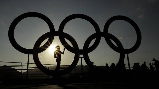 A woman is silhouetted by the setting sun in the Olympic Park in Rio