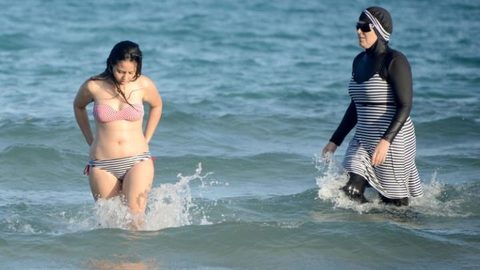 A woman wears a burkini-style swimsuit on a beach in Marseille southern France