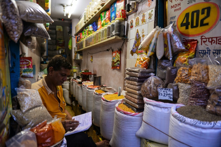 AFP  Chandan Khanna An Indian vendor works in his shop in the old quarters of New Delhi ahead of the landmark tax reform vote in parliament