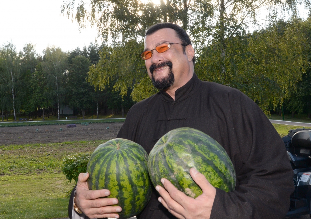 U.S. actor Steven Seagal holds two water melons during his meeting with the Belarus President at his residence