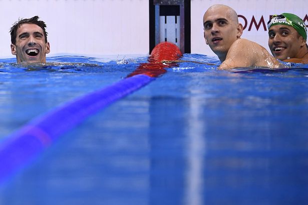 Michael Phelps smiles next to Laszlo Cseh and Chad Guy Bertrand Le Clos after placing second in the Men's 100m Butterfly Final