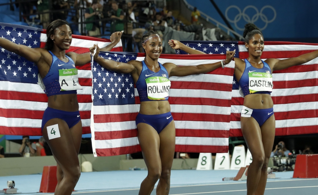 Gold medal winner Brianna Rollins silver medal winner Nia Ali and bronze medal winner Kristi Castlin all from the United States pose with their country's flag after the 100-meter hurdles final during the athletics competitions of the 2016 Summer