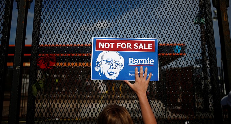 A supporter of Bernie Sanders holds a placard in protest at the perimeter walls of the Convention. REUTERS  Adrees Latif