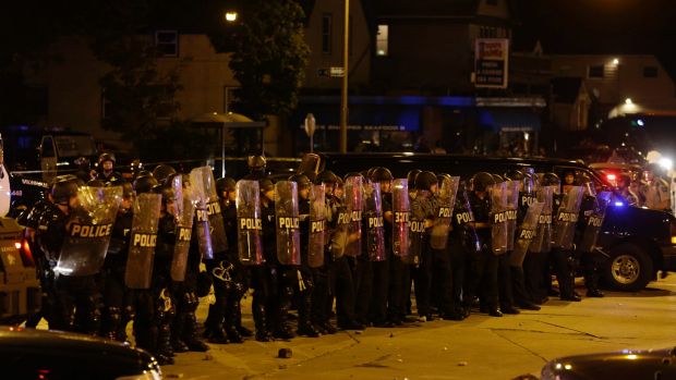 Police are pelted with rocks and shots rang out in Milwaukee Sunday Aug. 14 2016. Police said one person was shot