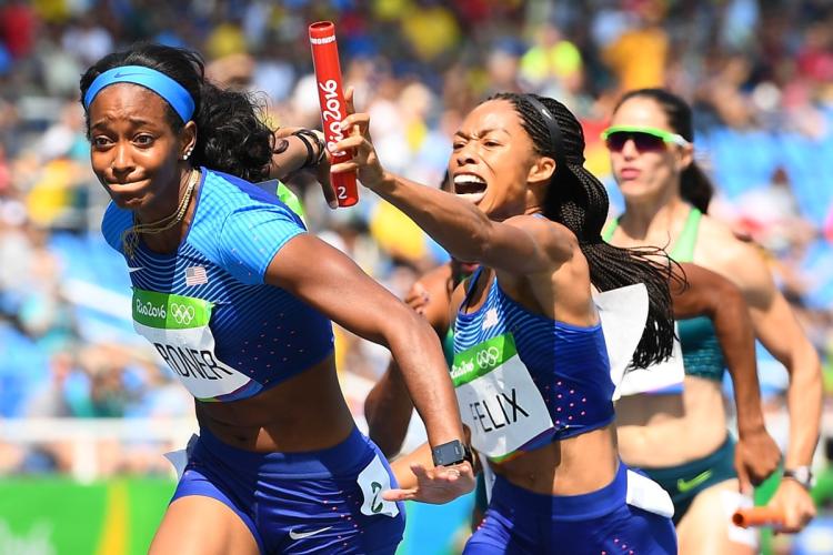 After being bumped Allyson Felix struggles to get the baton in the hands of English Gardner