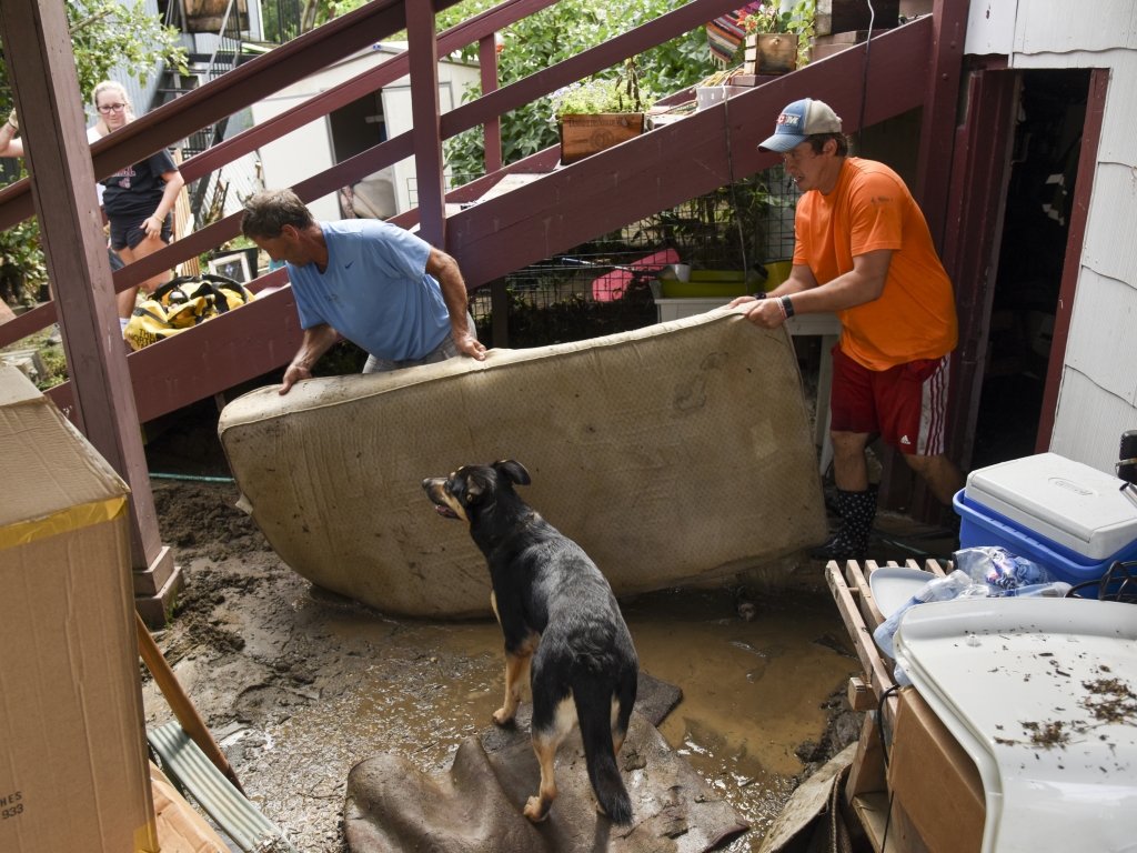 Al Miller helps clear Dan Durantaye's flooded basement after heavy floods devastated the historic district of Ellicott City on Sunday