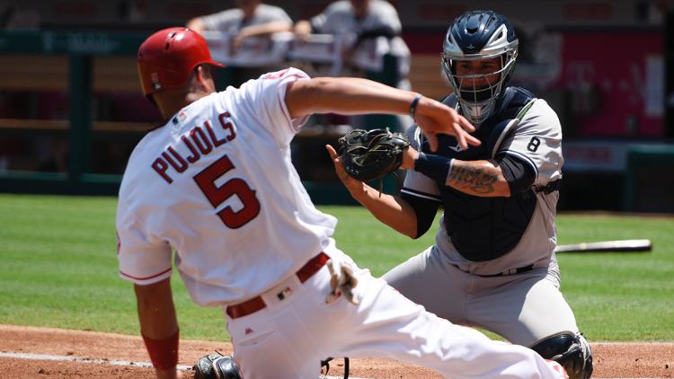 Albert Pujols beats Gary Sanchez's tag to score in the first inning. Pujols scored twice both times on singles by Andrelton Simmons