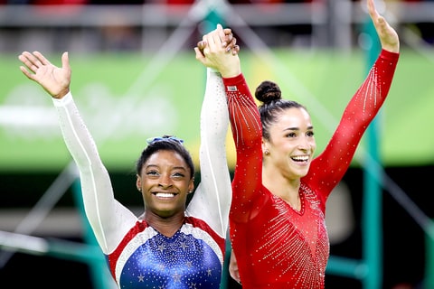 Simone Biles of the United State and Alexandra Raisman of the United States celebrate after winning Gold and Silver during the Artistic Gymnastics Women's Individual All Around Final at the Rio Olympic Arena