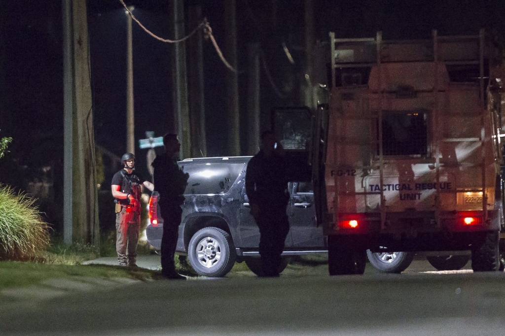 Police stand watch outside of a house in Strathroy Ontario Wednesday Aug. 10 2016. A suspect is dead after Canada's national police force thwarted what an official said was a suicide bomb plot