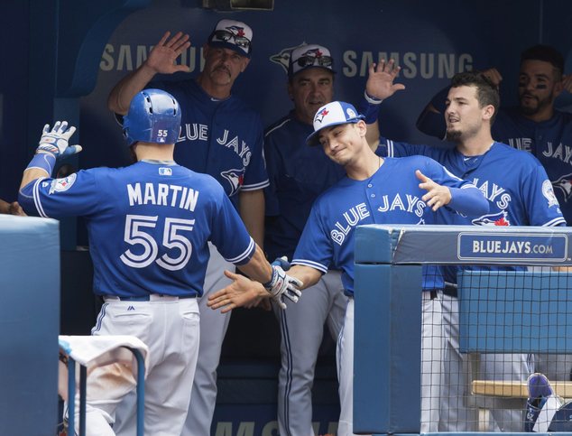 Toronto Blue Jays Russell Martin comes into dugout after he hit a solo home run against the Houston Astros during the fifth inning of a baseball game Sunday