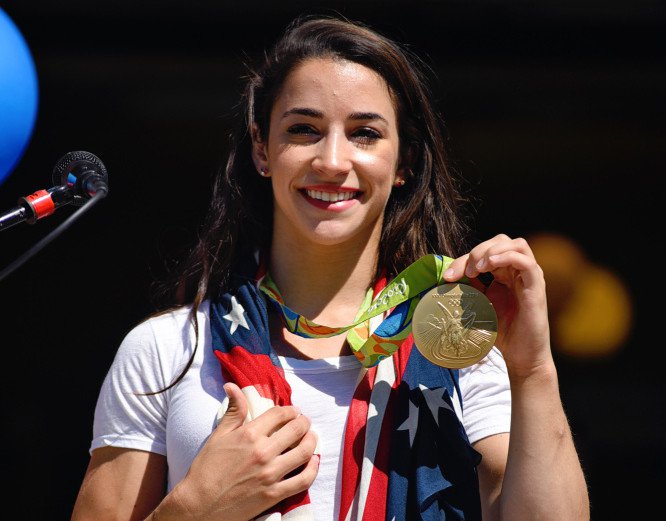 Aly Raisman shows off her gold medal at the Rally for Aly in Needham Mass. on Saturday