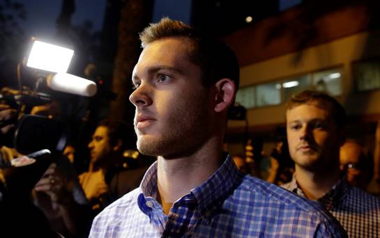 American Olympic swimmers Gunnar Bentz front and Jack Conger leave a police station in Rio