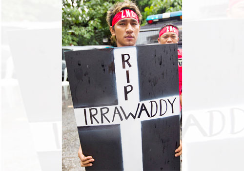 An activist holds a sign protesting the Myitsone dam in September