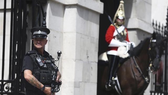 An armed police officer patrols Horse Guards in London on Wednesday