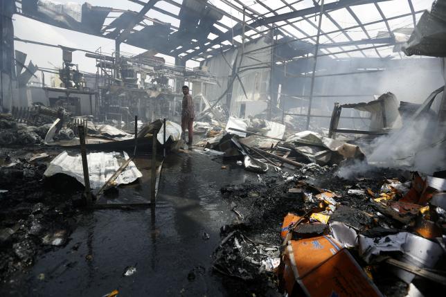 An employee walks inside a a snack food factory after a Saudi-led air strike hit it in Sanaa Yemen