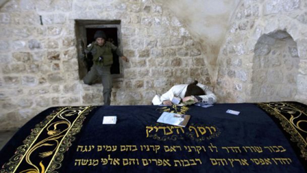 An ultra Orthodox Jewish woman prays at Joseph's Tomb in the West Bank city of Nablus early Monday