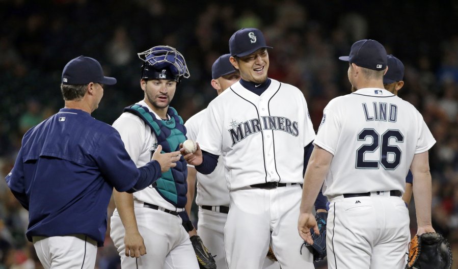 Hisashi Iwakuma smiles as he prepares to hand over the game ball while being relieved during the eighth inning Wednesday