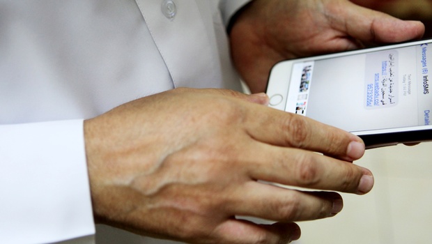 Human rights activist Ahmed Mansoor shows Associated Press journalists a screenshot of a spoof text message he received in Ajman United Arab Emirates on Thursday Aug. 25 2016. Mansoor was recently targeted by spyware that can hack into Apple's iPhone