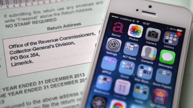 An Apple iPhone beside a tax return form as the tech giant faces a huge tax bill following an EU probe into its'sweetheart deal with the Irish Government