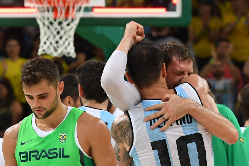 Argentina's shooting guard Carlos Delfino embraces Argentina's small forward Andres Nocioni as Brazil's