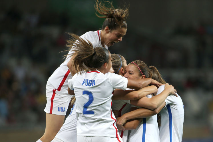 Alex Morgan second from right is engulfed by teammates after scoring in a 2-0 win over New Zealand