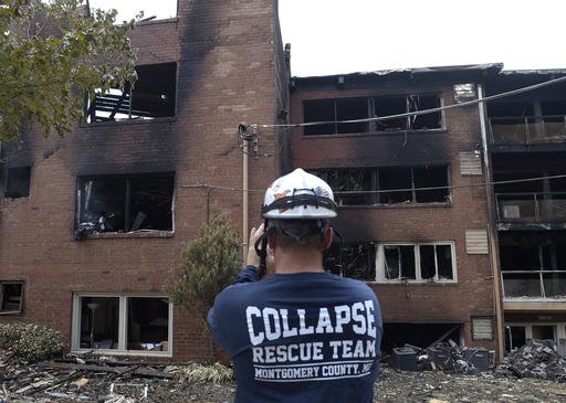 Emergency personnel view the scene of an apartment building fire in Silver Spring Md. Thursday Aug. 11 2016