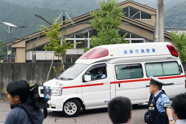 An ambulance moves past in front of a facility for the handicapped where a number of people were killed and dozens injured in a knife attack Tuesday