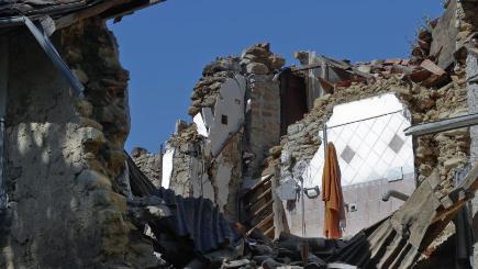 A bathrobe hangs from a wall of a collapsed house in Villa San Lorenzo a Flaviano near Amatrice central Italy