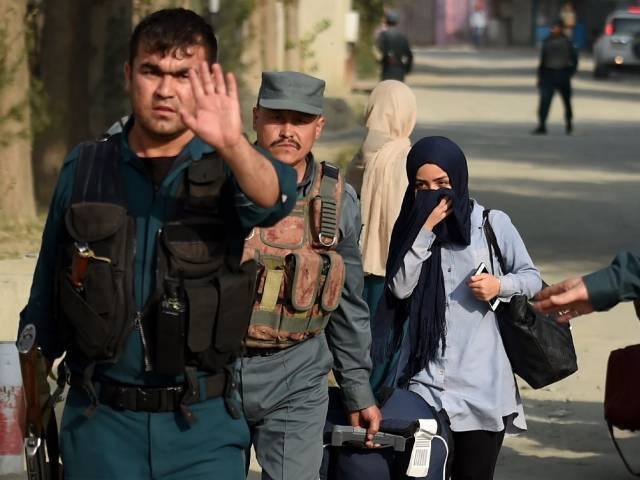 Afghan women students who were trapped inside the American University of Afghanistan in Kabul during an attack by militants are escorted by police after a nearly 10-hour raid