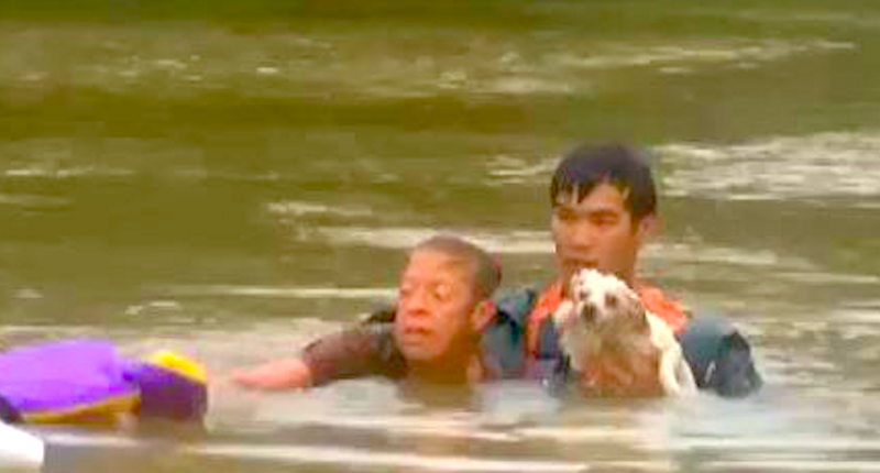 A woman and her dog after being rescued from a sinking car in Louisiana