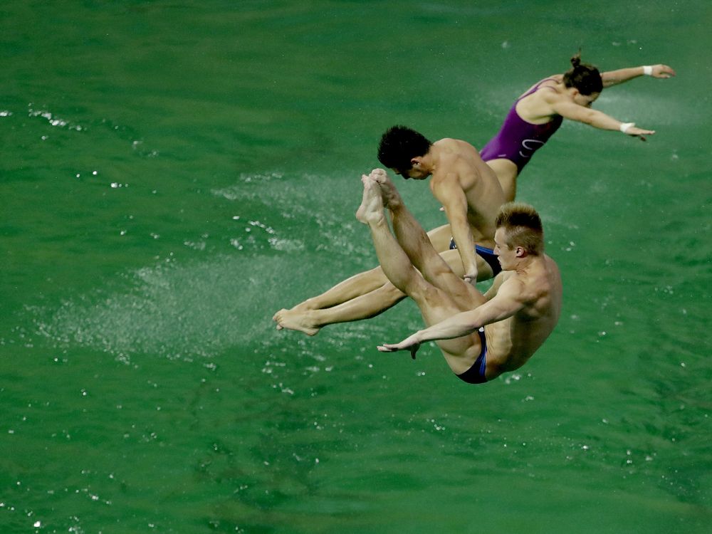 Athletes perform training dives on Wednesday at the Maria Lenk Aquatic Centre diving pool in Rio