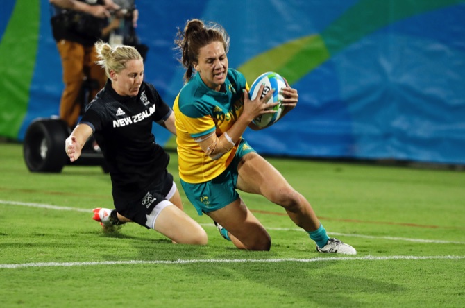 Australia’s Evania Pelite scores a try as New Zealand’s Kelly Brazier chasses during the women’s rugby sevens gold medal match