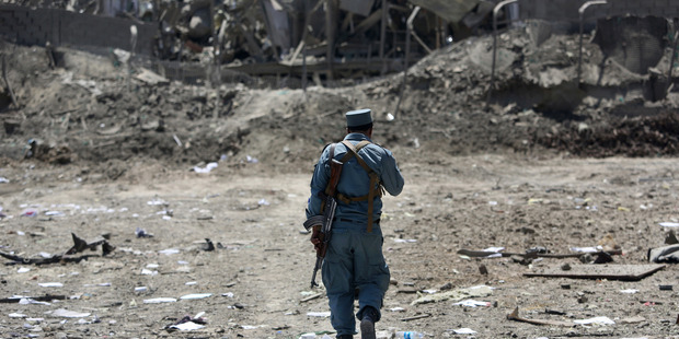 An Afghan Security policeman inspects the site of a suicide truck bombing in Kabul last week. Afghanistan remains locked in a violent insurgency