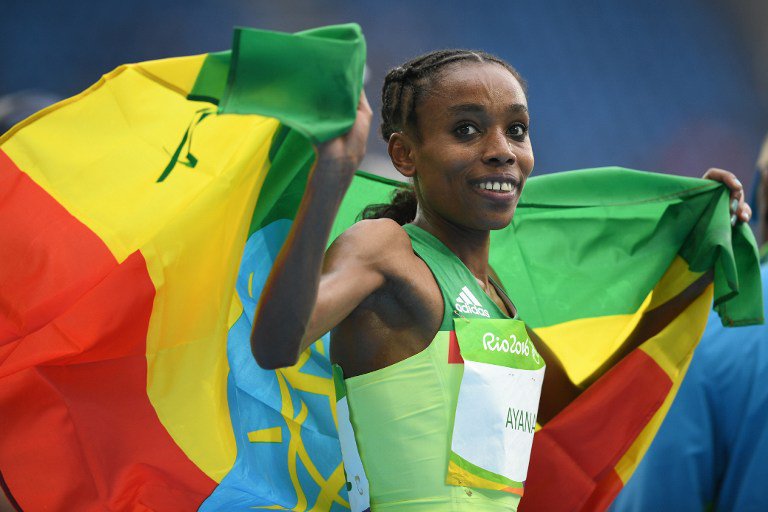 Gold medallist Ethiopia's Almaz Ayana runs with Ethiopia's national flag after the Women's 10,000m during the athletics event at the Rio 2016 Olympic Games at the Olympic Stadium in Rio de Janeiro