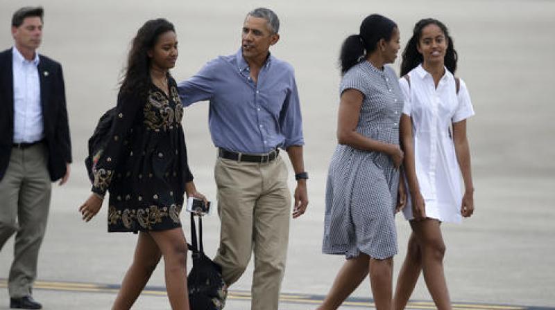 President Barack Obama center and first lady Michelle Obama second from right walk with their daughters Sasha left and Malia