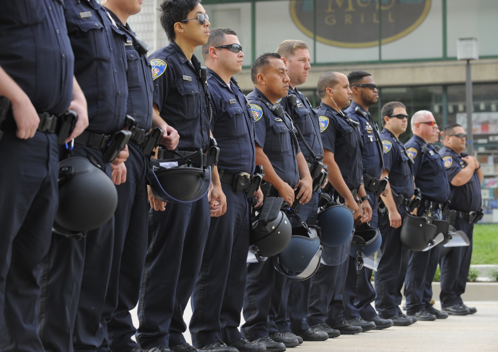 FILE- Baltimore police officers form a line at the Inner Harbor on Pratt Street as protestors gathered blocking traffic Wednesday Sept. 2 2015 in Baltimore as the first court hearing was set to begin in the case of six police officers criminally cha