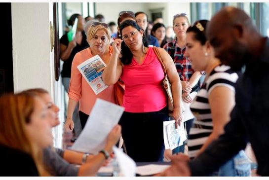 Reina Borges left stands in line to apply for a job with Aldi at a job fair in Miami Lakes Fla. On Friday Aug. 5 the Labor Department issues its jobs report for July