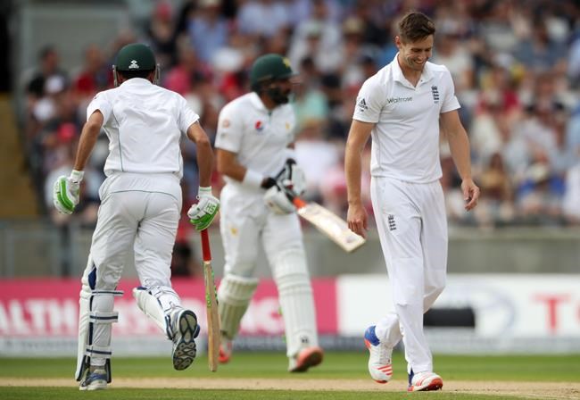 England's bowler Chris Woakes foreground walks back to his mark as Pakistan's Misbah-ul Haq and Younus Khan add to their overnight score during day three of the 3rd Test Match at Edgbaston cricket ground in Birmingham England Friday Aug. 5 201