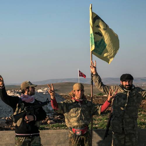 Syrian Kurdish militia members of the YPG make a V-sign next to a drawing of Abdullah Ocalan jailed Kurdish rebel leader in Esme village in Aleppo province Syria. A Turkish military expedition into Syria