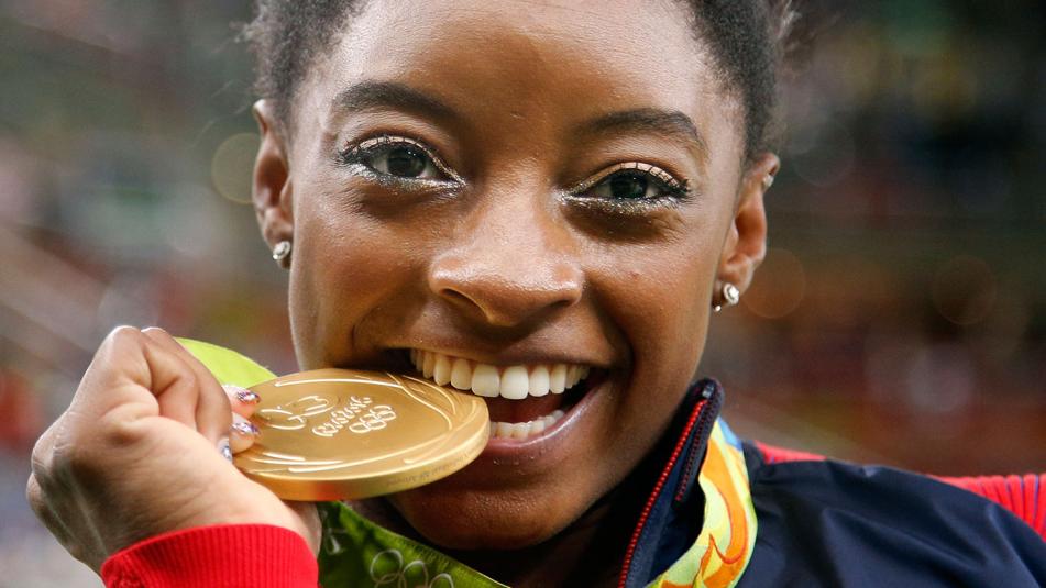 Simone Biles bites her all-around gold medal