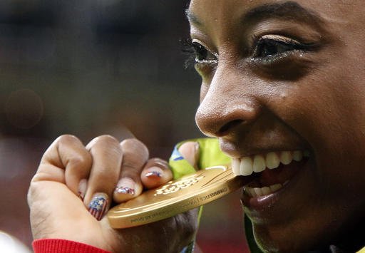 United States Simone Biles bites her gold medal for the artistic gymnastics women's individual all-around final at the 2016 Summer Olympics in Rio de Janeiro Brazil Thursday Aug. 11 2016