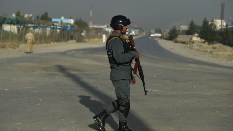 An Afghan policeman walks near the site where a truck bomb exploded targeting a hotel used by foreign contractors on the outskirts of Kabul