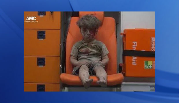 In this frame grab taken from video provided by the Syrian anti-government activist group Aleppo Media Center, a child sits in an ambulance after being pulled out or a building hit by an airstirke in Aleppo Syria Wednesday Aug. 17 2016. Syrian