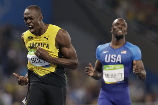 Usain Bolt from Jamaica left celebrates winning the gold medal in the men's 200-meter final during the athletics competitions of the 2016 Summer Olympics at the Olympic stadium in Rio de Janeiro Brazil Thursday Aug. 18 2016. AP