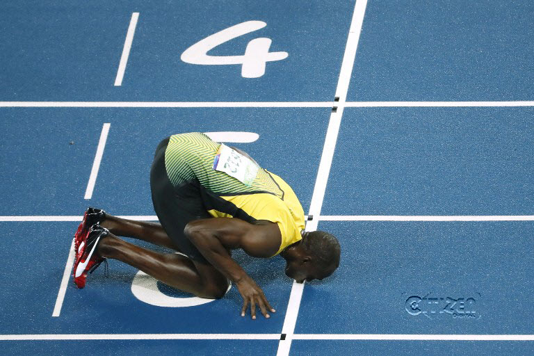 Jamaica's Usain Bolt kisses the track as he celebrates after winning the Men's 200m Final