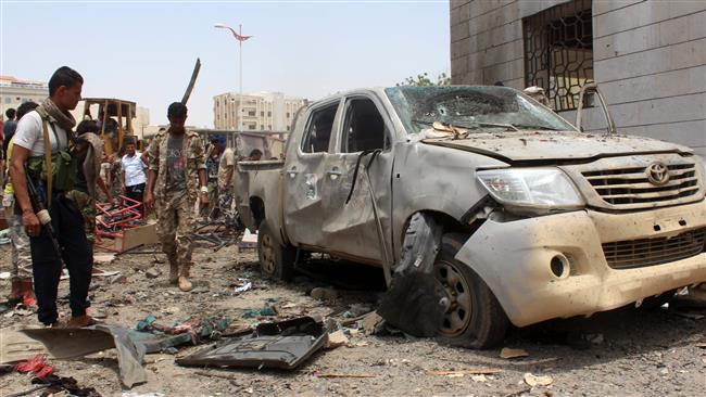 Yemenis inspect debris at the site of a car bombing attack claimed by the Daesh Takfiri terrorist group