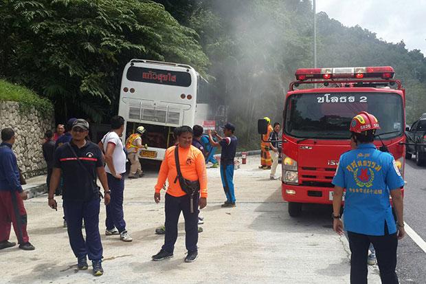 Rescue workers retrieve three injured Chinese tourists from a white tour bus which crashed into a barrier while going down the Patong hill in Kathu district of Phuket on Friday morning