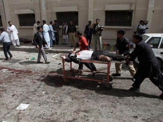 Police and hospital staff move a victim of a suspected suicide bomb blast outside a hospital in Quetta Pakistan on Monday